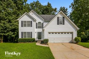 Gainesville house for rent - a white house with a white garage door and a driveway