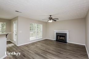 Gainesville house for rent - a living room with a fireplace and a ceiling fan
