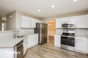 Gainesville house for rent - a kitchen with white cabinets and stainless steel appliances