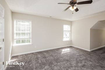 Gainesville house for rent - a living room with carpet and a ceiling fan