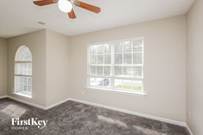 Gainesville house for rent - a bedroom with two windows and a ceiling fan