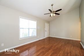 Winston Salem house for rent - A room with a ceiling fan and wooden floors.