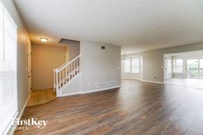 Galloway house for rent - A spacious room with wooden floors and a staircase leading to another room.