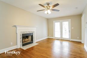 Holly Springs house for rent - a living room with a fireplace and a ceiling fan