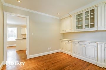 Holly Springs house for rent - a kitchen with white cabinets and a wood floor