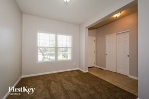 St Charles house for rent - the living room of an empty home with white doors and a window