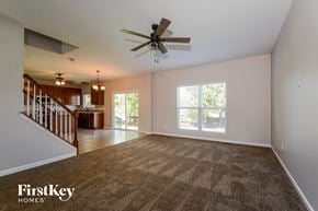St Charles house for rent - an empty living room with carpet and a ceiling fan