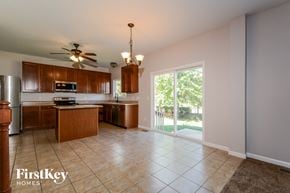 St Charles house for rent - a kitchen with wooden cabinets and a sliding glass door to a patio