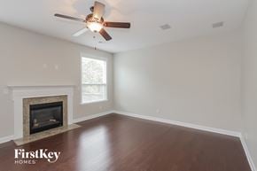 Charlotte house for rent - a living room with a ceiling fan and a fireplace