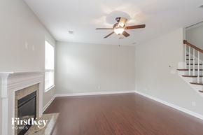 Charlotte house for rent - a living room with a fireplace and a ceiling fan