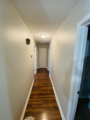 Lafayette house for rent - A long hallway with wood floors and white walls.