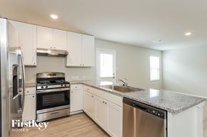 Converse house for rent - a kitchen with white cabinets and granite counter tops and stainless steel appliances