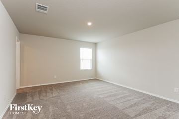 Converse house for rent - a spacious living room with carpet and a window