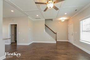 Clayton house for rent - A spacious room with a wooden floor and a staircase.
