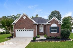 Stanley house for rent - a brick house with a white garage door and a lawn