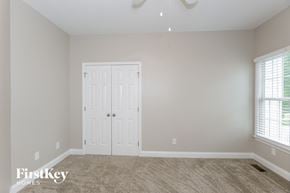 Stanley house for rent - a bedroom with a white door and a carpeted floor
