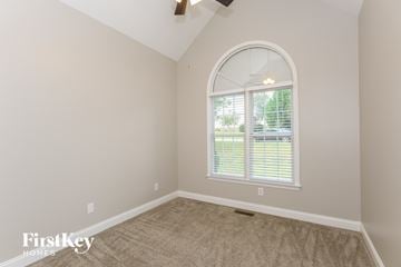 Stanley house for rent - a living room with an arched window and carpet