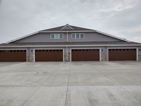 Belgium apartment for rent - the front of a garage with two brown garage doors