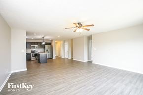Whitestown house for rent - A spacious room with a ceiling fan and wooden flooring.