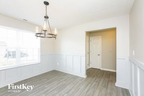 Whitestown house for rent - A room with a wooden floor and a chandelier hanging from the ceiling.