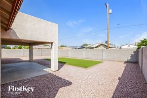 Glendale house for rent - a backyard with a grass lawn and a concrete wall