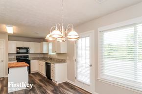 Dallas house for rent - a kitchen with white cabinets and a large window