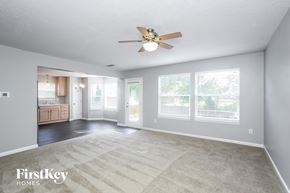 Westfield house for rent - an empty living room with a ceiling fan and a kitchen