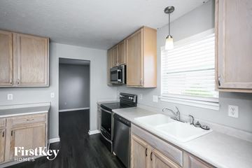 Westfield house for rent - a kitchen with wooden cabinets and a sink and a window