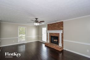 Powder Springs house for rent - a living room with a brick fireplace and a ceiling fan