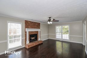 Powder Springs house for rent - a living room with a brick fireplace and a ceiling fan