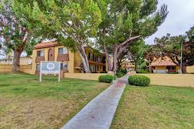 San Diego apartment for rent - a sidewalk in front of a house with trees and a sign