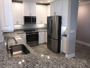 Bradenton house for rent - a kitchen with granite counter tops and stainless steel appliances