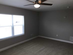 Bradenton house for rent - a bedroom with a ceiling fan and a window