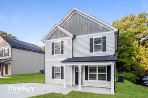 Kannapolis house for rent - the front of a white house with a gray roof and a driveway