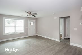 Kannapolis house for rent - a bedroom with a ceiling fan and white walls and wood floors