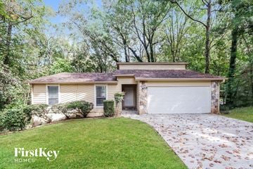 Stone Mountain house for rent - a small yellow house with a driveway and a garage door