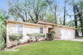 Stone Mountain house for rent - a small yellow house with two white garage doors