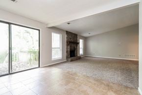 Stone Mountain house for rent - an empty living room with a fireplace and sliding glass doors