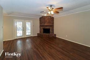 Arlington house for rent - the living room of a house with a fireplace and a ceiling fan