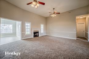 North Charleston house for rent - A spacious room with a fireplace and a ceiling fan.