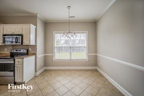 North Charleston house for rent - A kitchen with a microwave, oven, and a window with blinds.