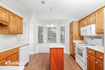 Greensboro house for rent - a kitchen with white appliances and wooden cabinets