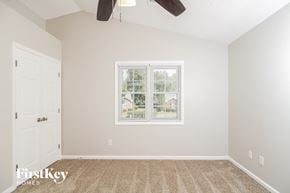 Greensboro house for rent - a bedroom with a large window and a white door