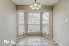 Desoto house for rent - an empty dining room with three windows and a chandelier