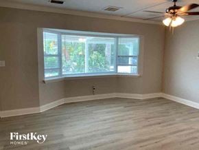 Largo house for rent - an empty living room with a large window and a ceiling fan