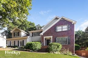 Lawrenceville house for rent - a brick house with white siding and a lawn