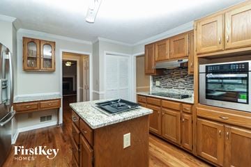 Lawrenceville house for rent - a kitchen with wooden cabinets and a granite counter top