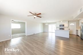 Glendale house for rent - an empty living room and kitchen with a ceiling fan