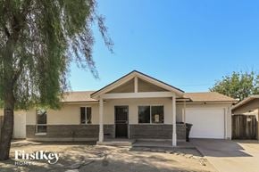 Phoenix house for rent - the front of a house with a garage and a tree