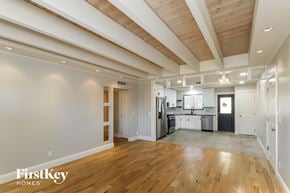 Phoenix house for rent - an open kitchen and living room with wood floors and white ceilings